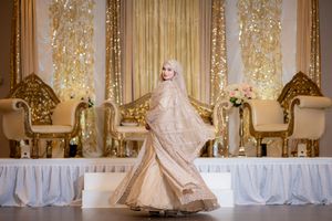 Elegant wedding venue with ornate gold decor and white drapery.