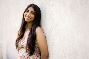 Portrait series of a woman in casual attire against a white wall.