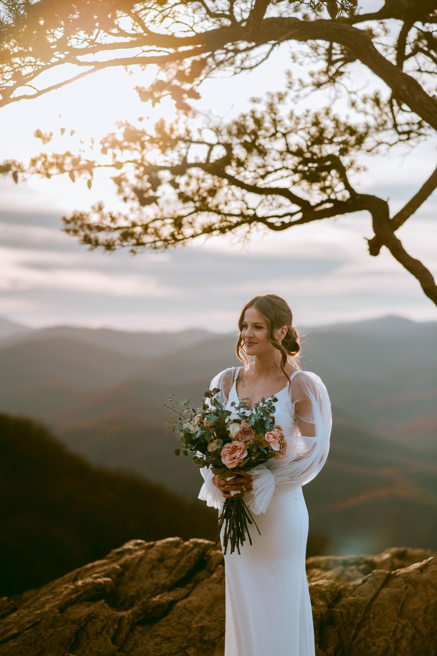 Bride standing with her bouquet with a mountain view backdrop