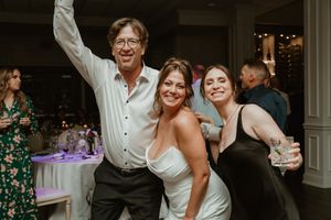 Energetic wedding reception celebration with guests dancing and enjoying festivities.