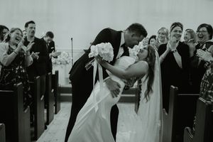 Wedding party celebrates joyfully with group photos outdoors in formal attire.