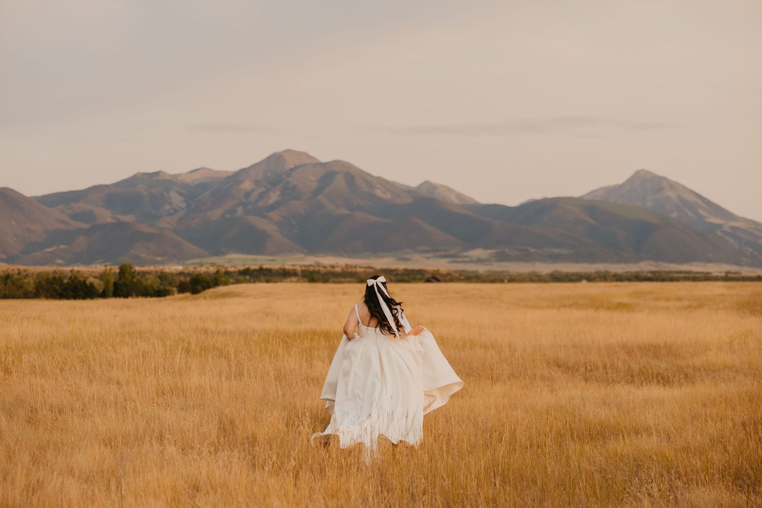 Paradise Valley Bride running away into the Mountains captured by Pray, Montana Wedding Photographer. Paradise Valley Wedding Photographer
