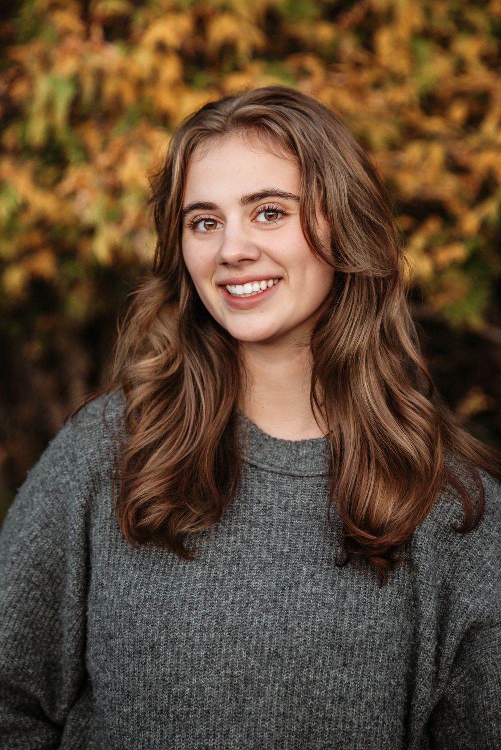 A sequence of outdoor portrait shots showing someone in a grey sweater with autumn foliage in the background.