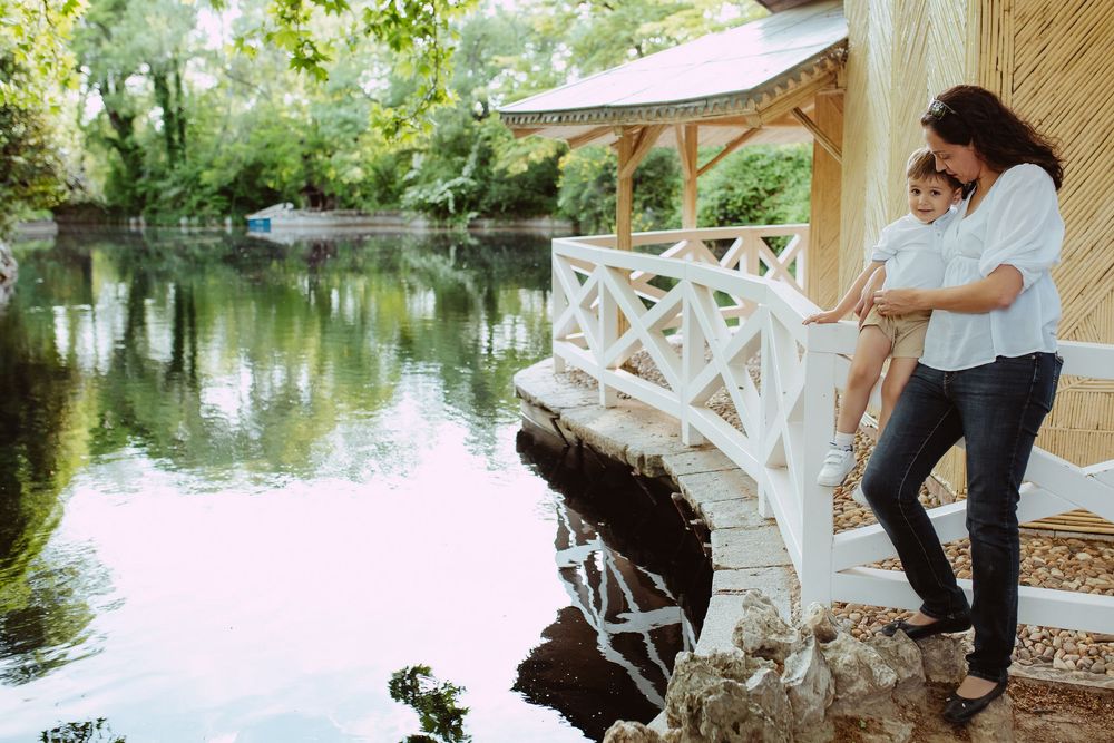 Family spending quality time together by a tranquil lake with wooden gazebo.