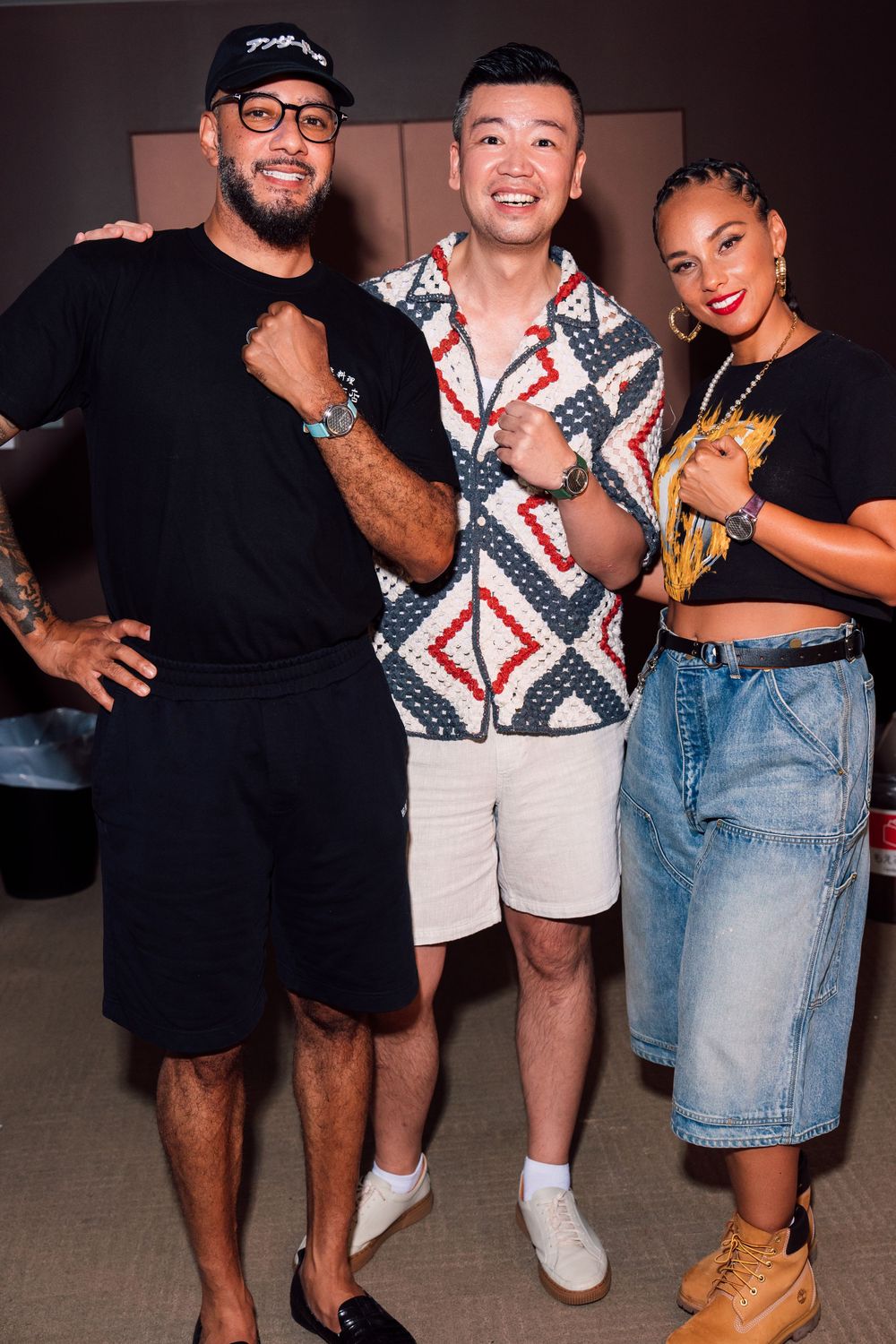 Alicia keys and Swizz Beatz in Tokyo
Three people posing together at a party, wearing casual outfits including shorts, jeans and a crop top.
