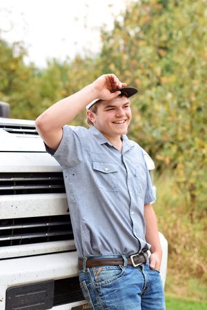 Young person in light blue shirt and jeans poses casually against white background in outdoor setting.