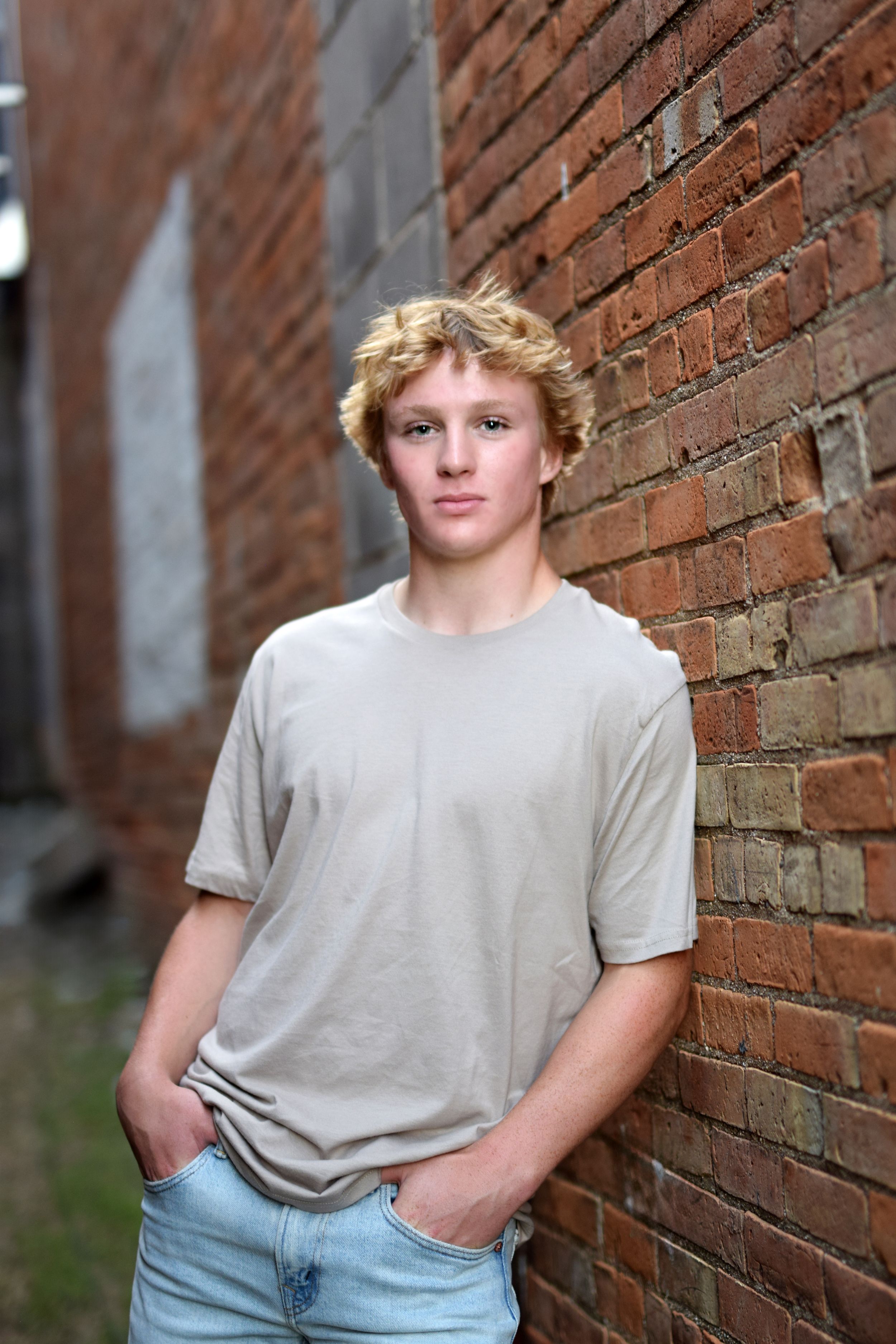 Casual portrait against red brick wall in urban setting.
