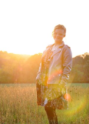 Portrait in a field at golden hour with warm sunlight creating a dreamy atmosphere.