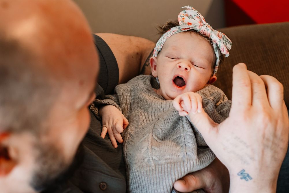 Collage of black and white newborn photos showing sleepy yawning expressions and tiny details of a baby.