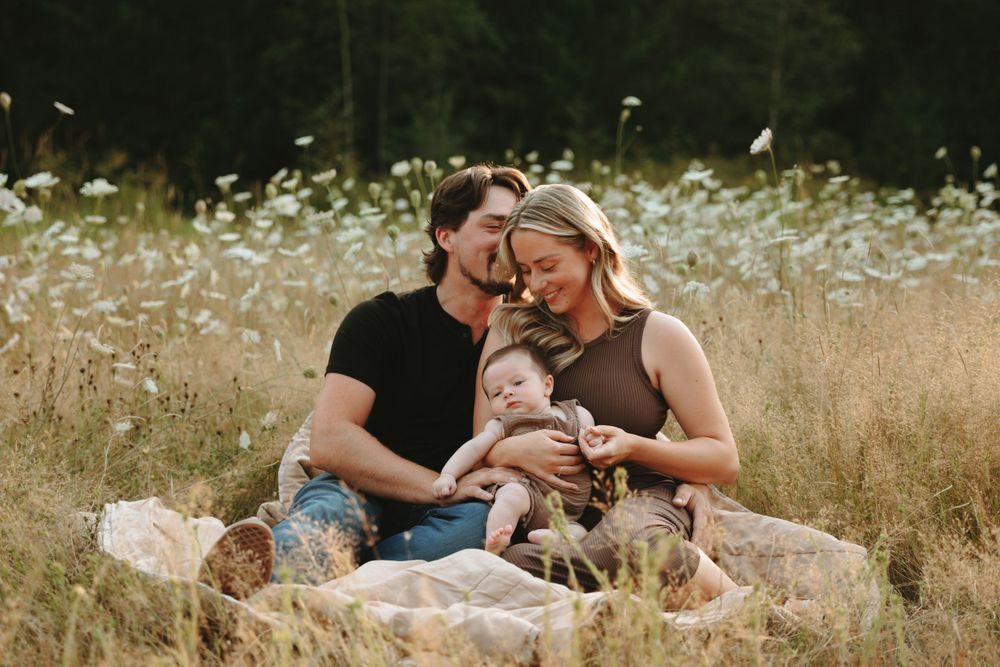 Family enjoying a picnic together in a golden wheat field on a warm summer afternoon.