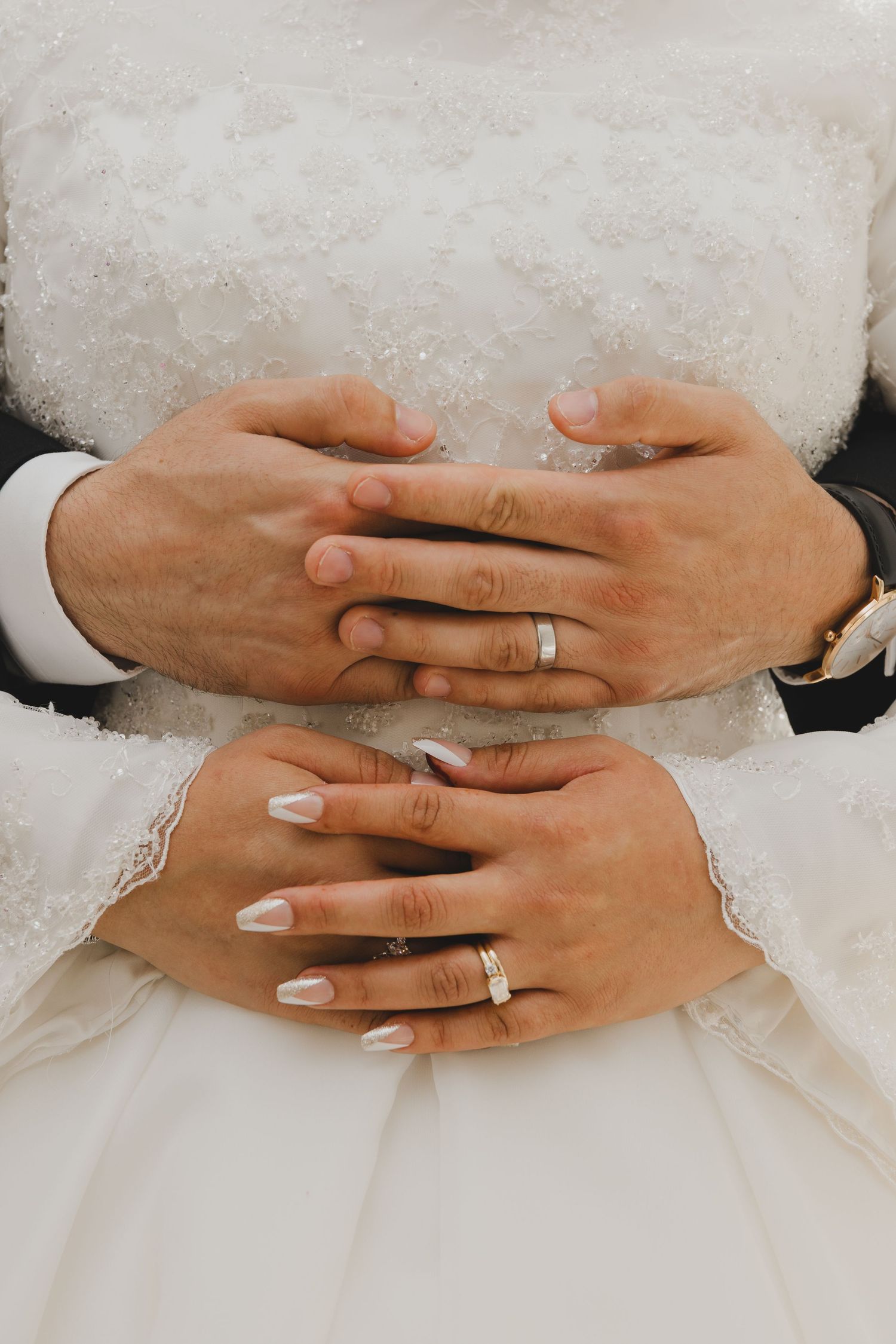 Close-up of bride’s hands holding bouquet with wedding ring