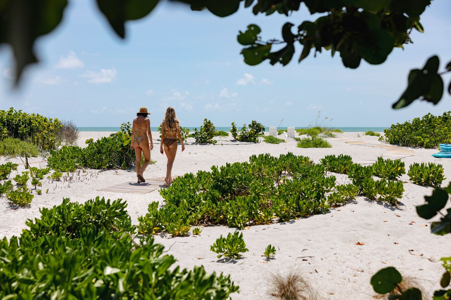 Tranquil beach scene with white sandy shore and turquoise ocean waters under sunny skies.