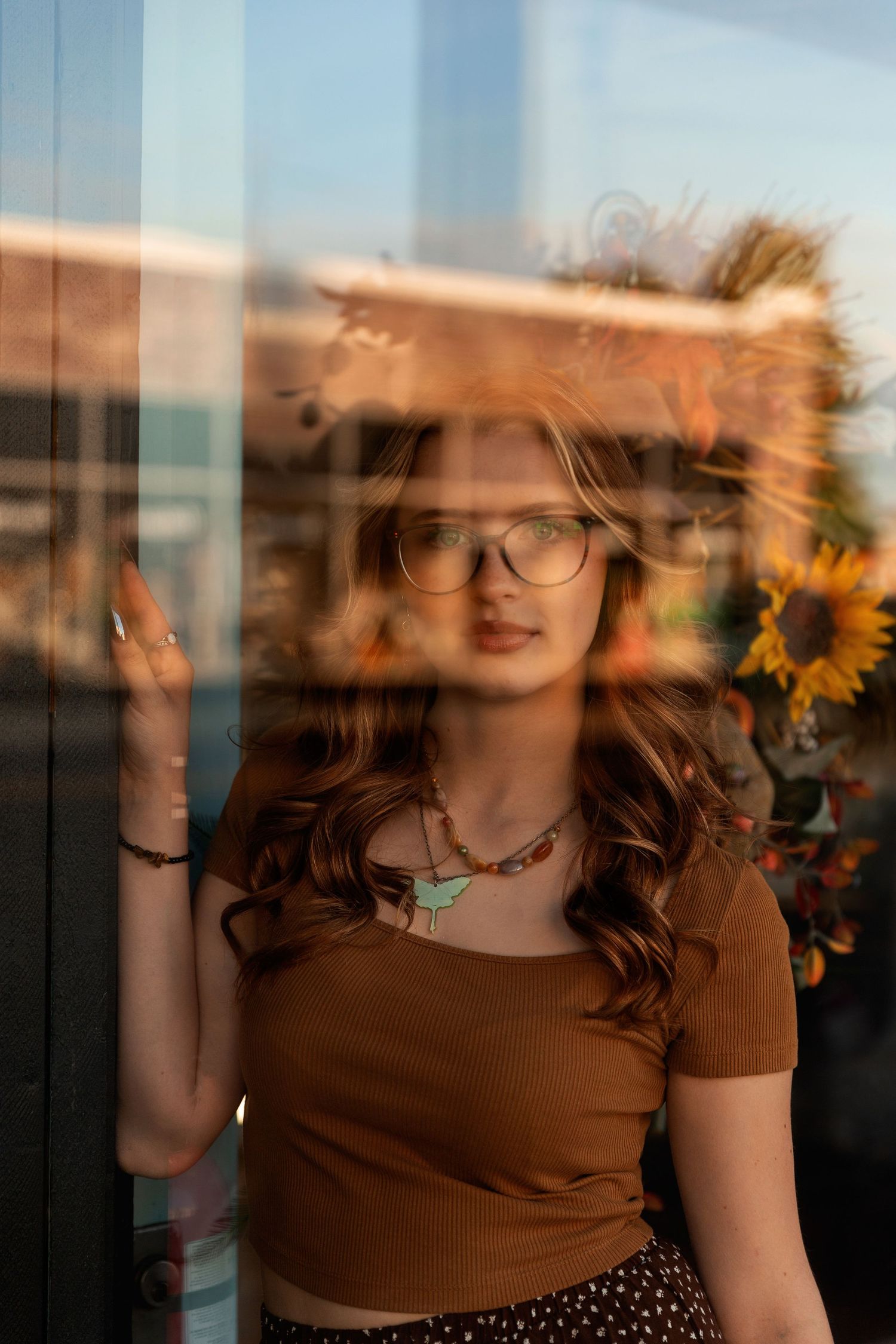 Person sitting in tall autumn grass during golden hour portrait session.