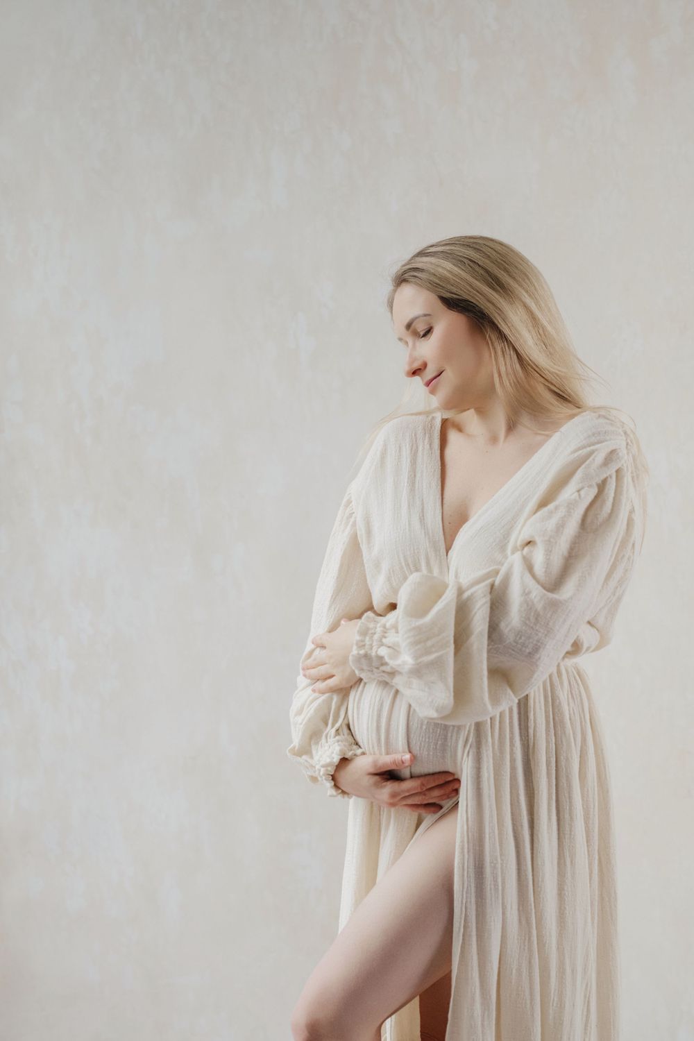 Dreamy maternity boudoir photo with romantic white dress in soft natural light. Bellevue studio, WA