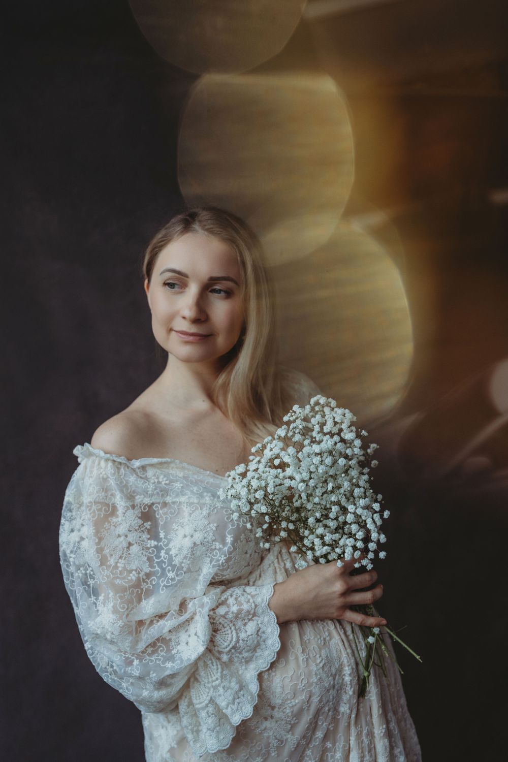 Dreamy portrait with baby's breath bouquet and lace dress against dark background. Bellevue studio, WA