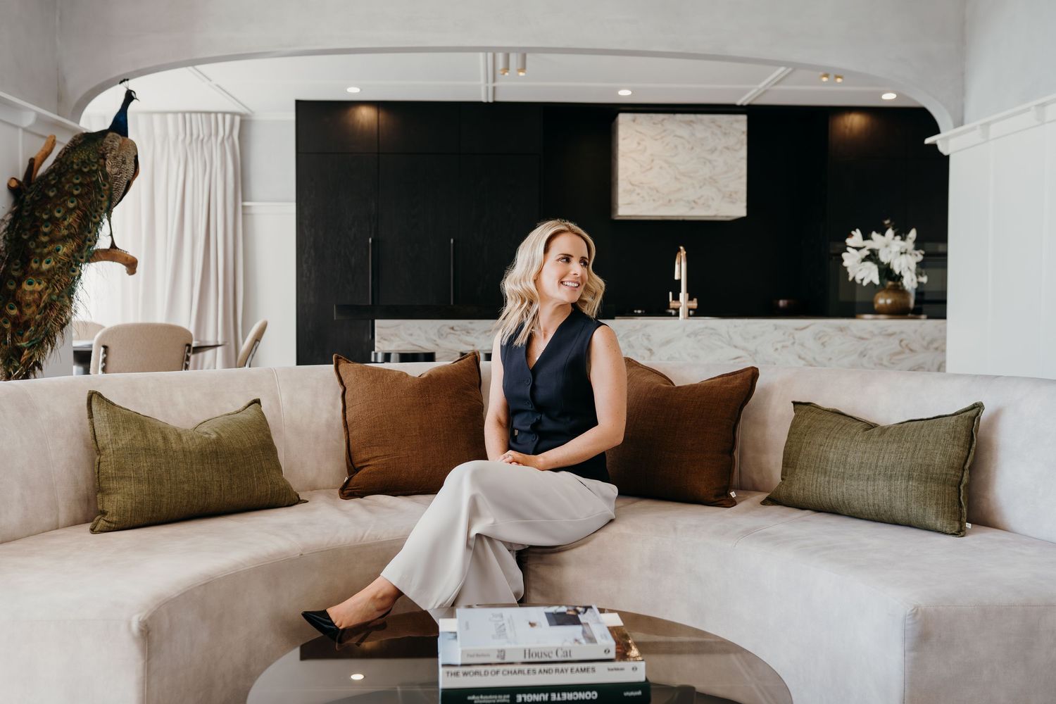 Elegant living room interior with white sofa, neutral decor, and coffee table styling in a contemporary home setting.