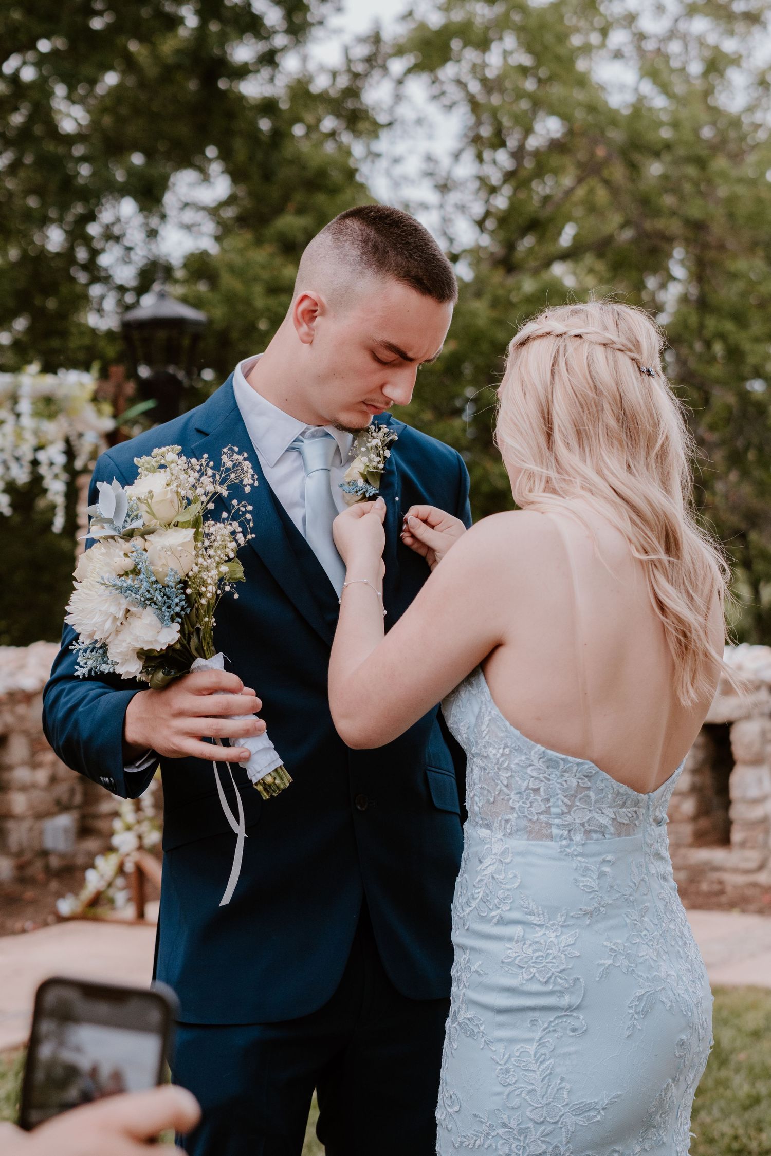 Couple in wedding attire sharing intimate first look moments in an outdoor garden setting.