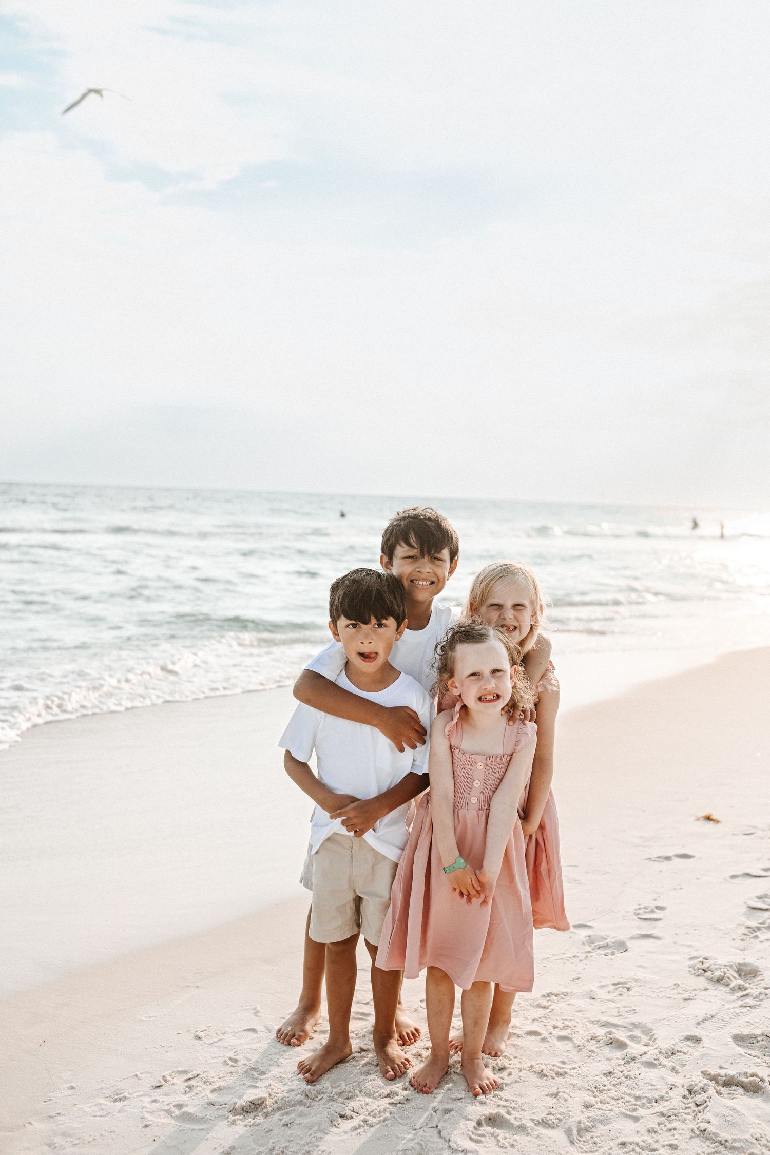 Children play and laugh together on pristine white sand beach.