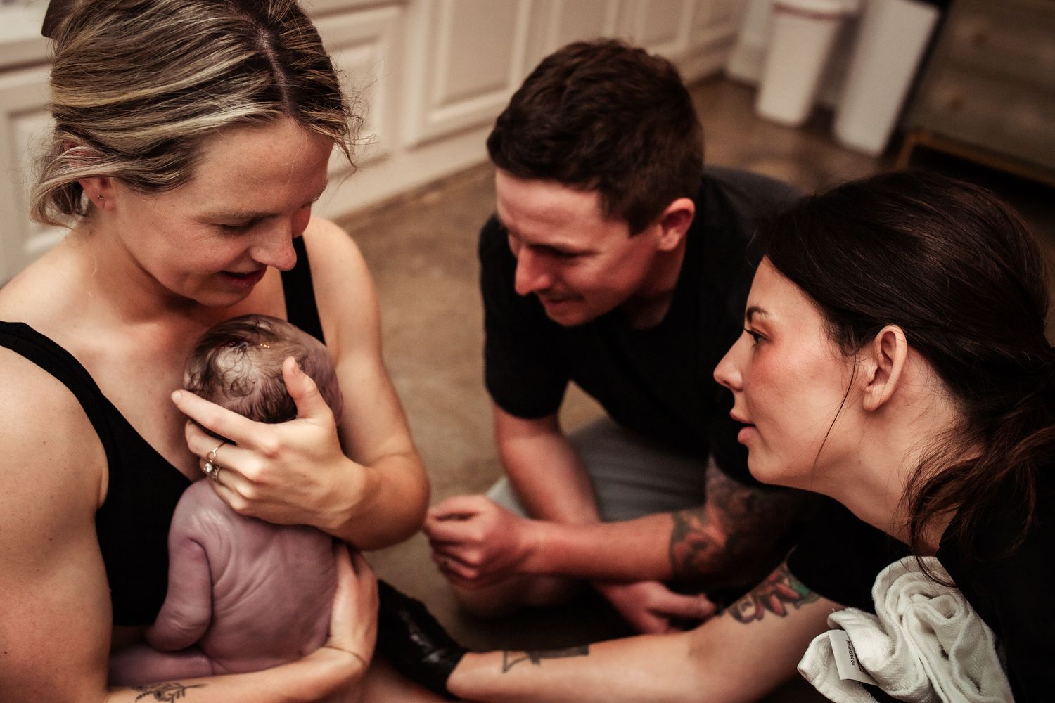 MOM-CATHES-BABY-ON-THE-FLOOR-AT-ORIGINS-BIRTH-CENTER-KELLER-WITH-SUPPORT-FROM-HUSBAND-AND-MIDWIFE-MALLORY-TUTTON
