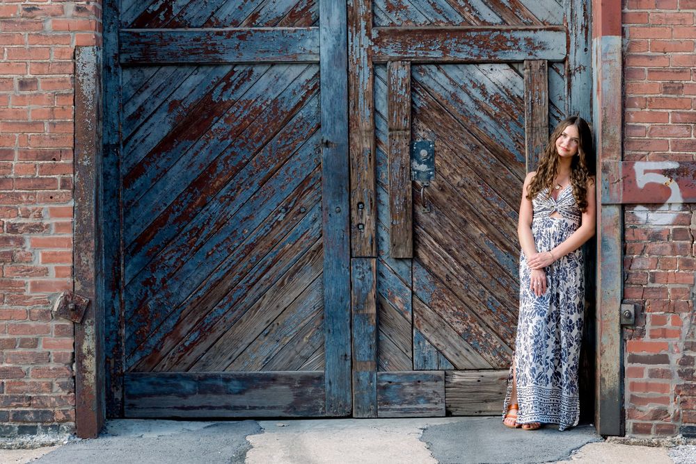 A rustic wooden door entrance with diagonal planks against weathered red brick walls.