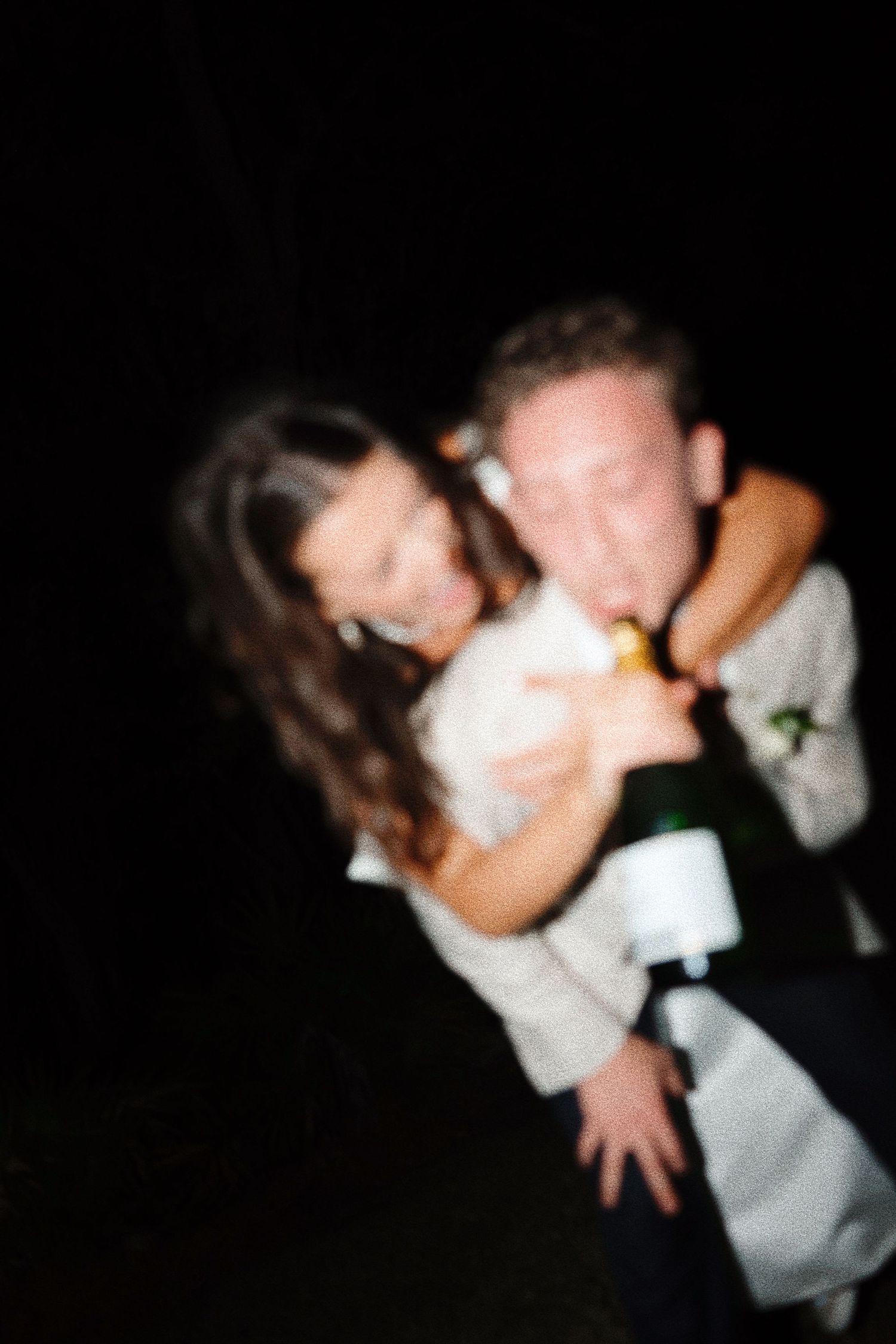 Intimate dance moment captured in soft focus with black background.