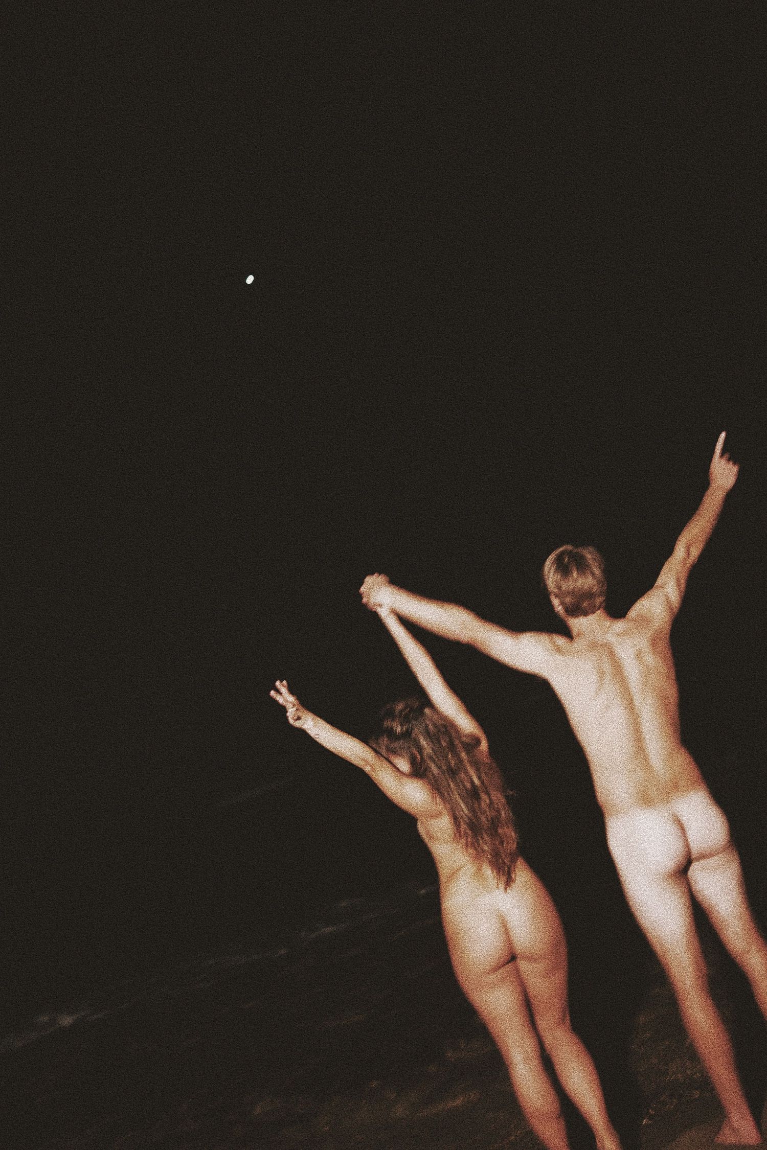 A series of nude figures dancing in silhouette against a dark background, creating an artistic composition.