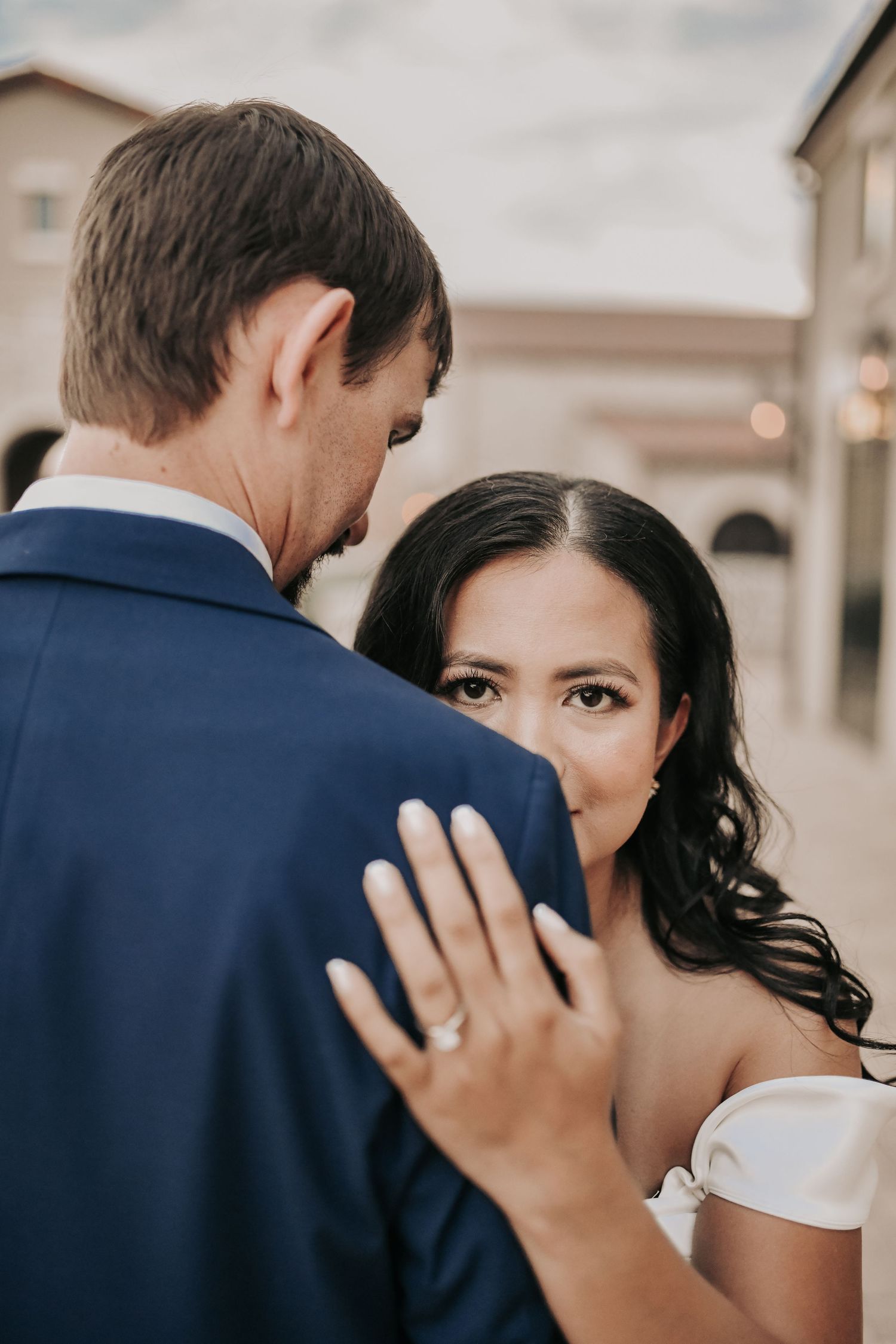 Elegant couple photographed against stone walls and black iron details during their engagement session