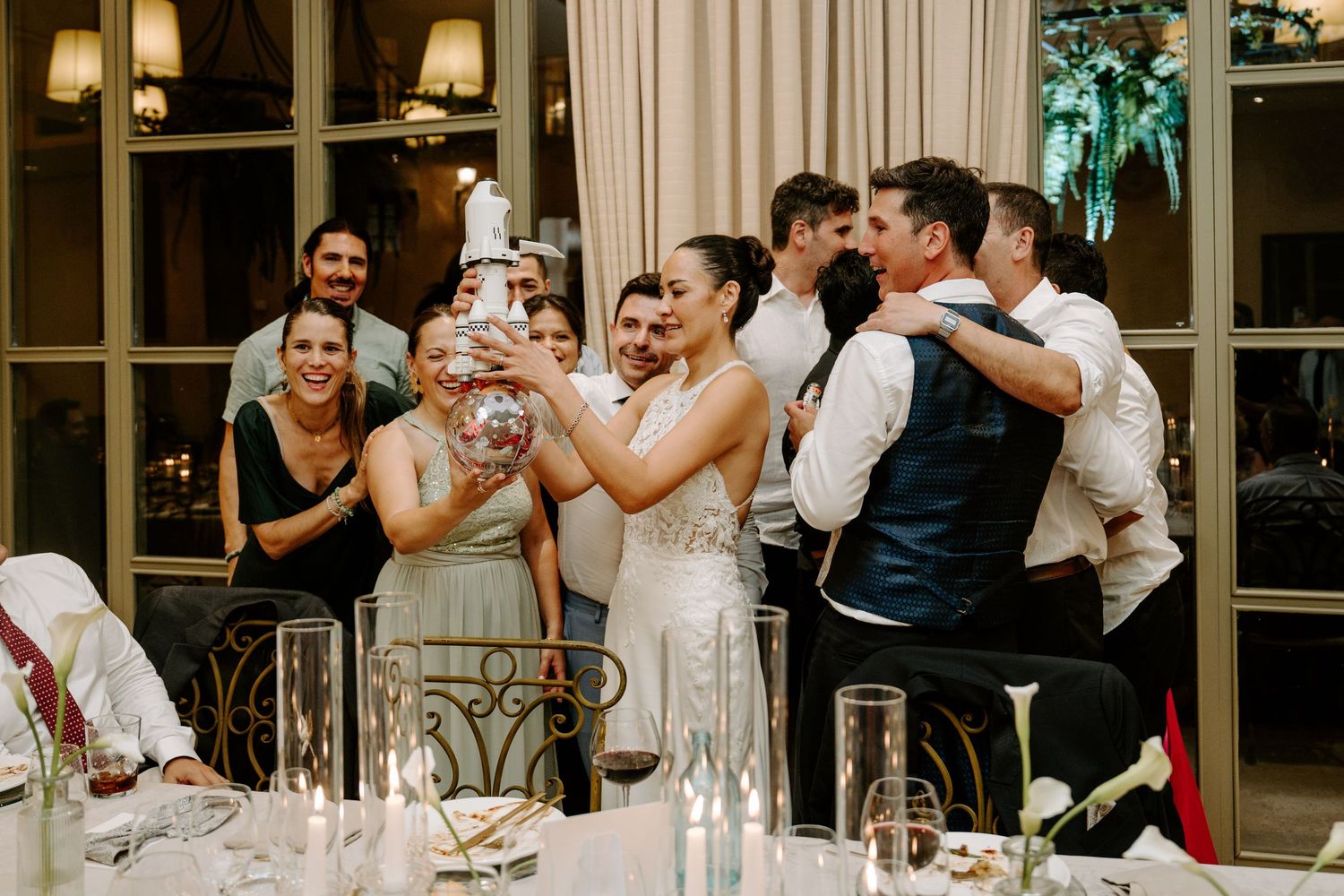 Bride and wedding guests laugh and celebrate together during lively wedding reception party.