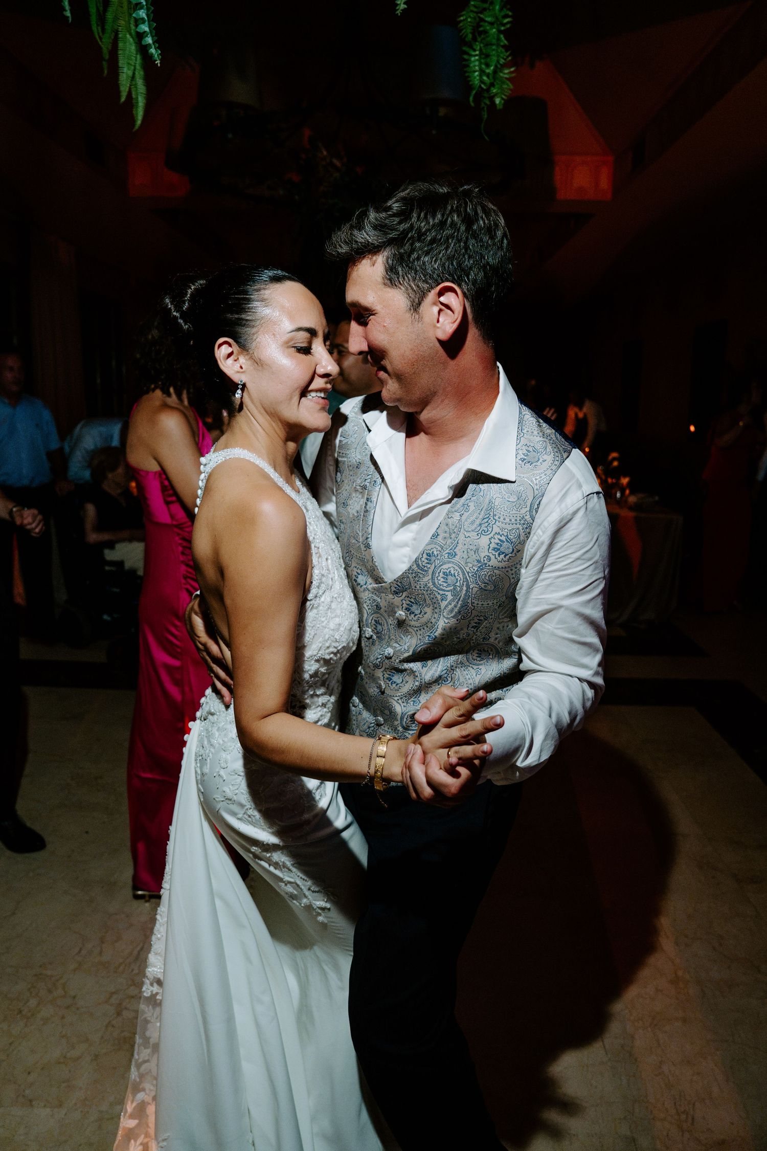 Bride and groom share an intimate first dance, smiling at each other during their wedding reception.
