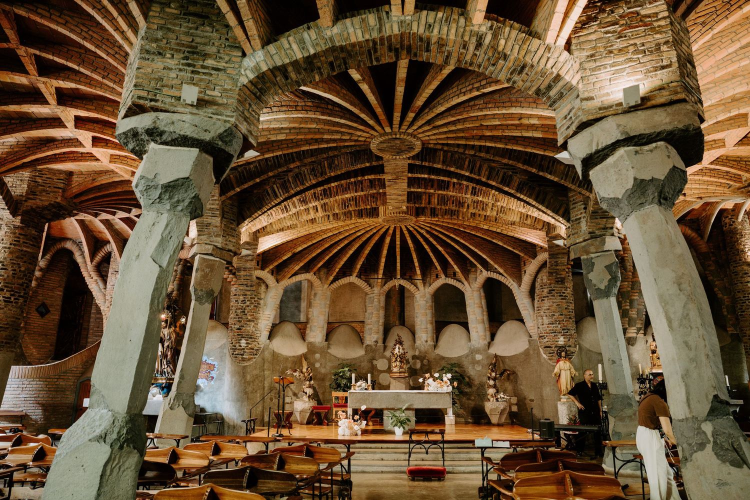 Stunning interior of an ancient stone church with radial vaulted ceiling, columns, and ornate altar.