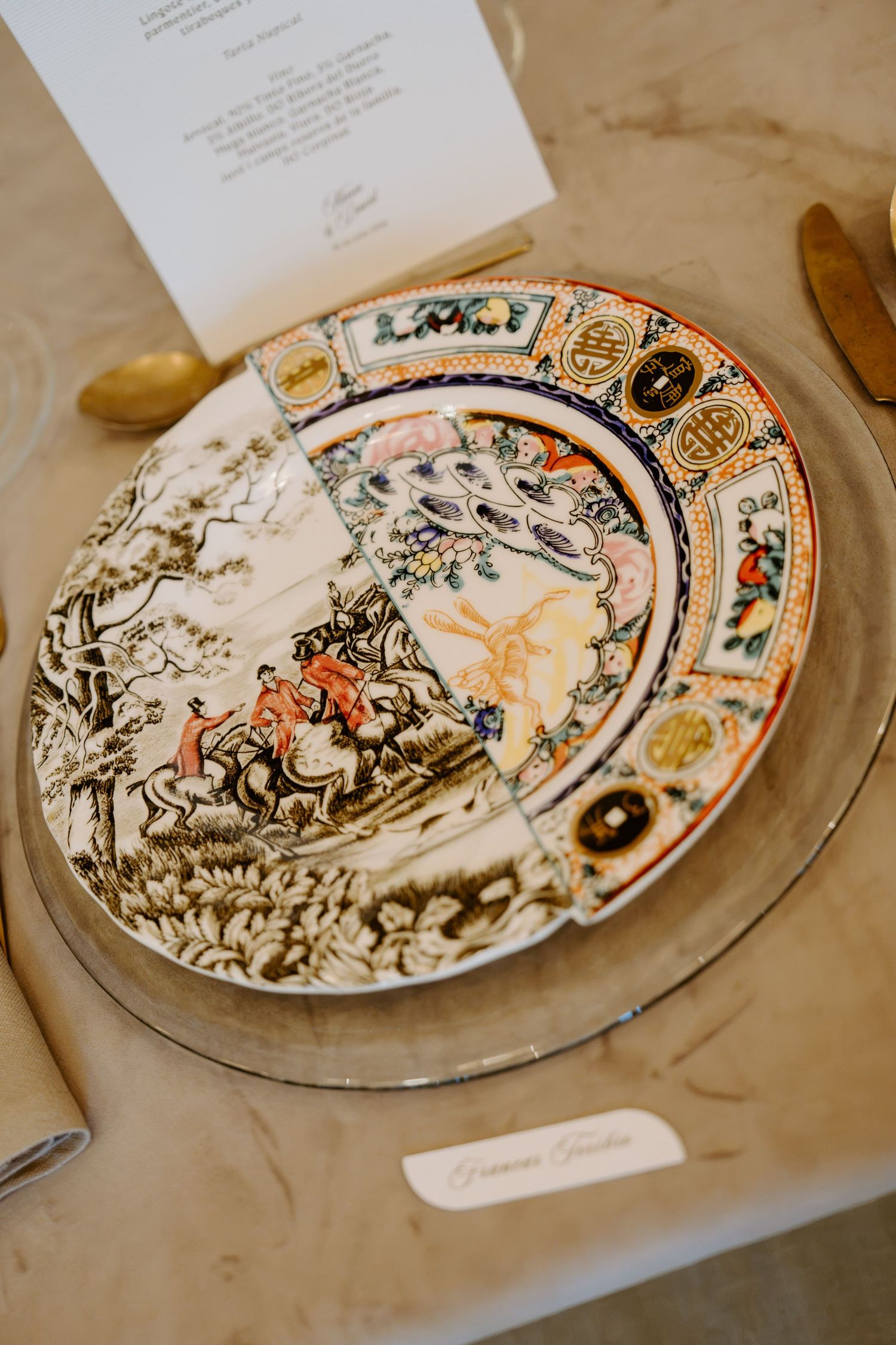 Ornate antique decorative plate with hunting scene place setting and gold cutlery at wedding.