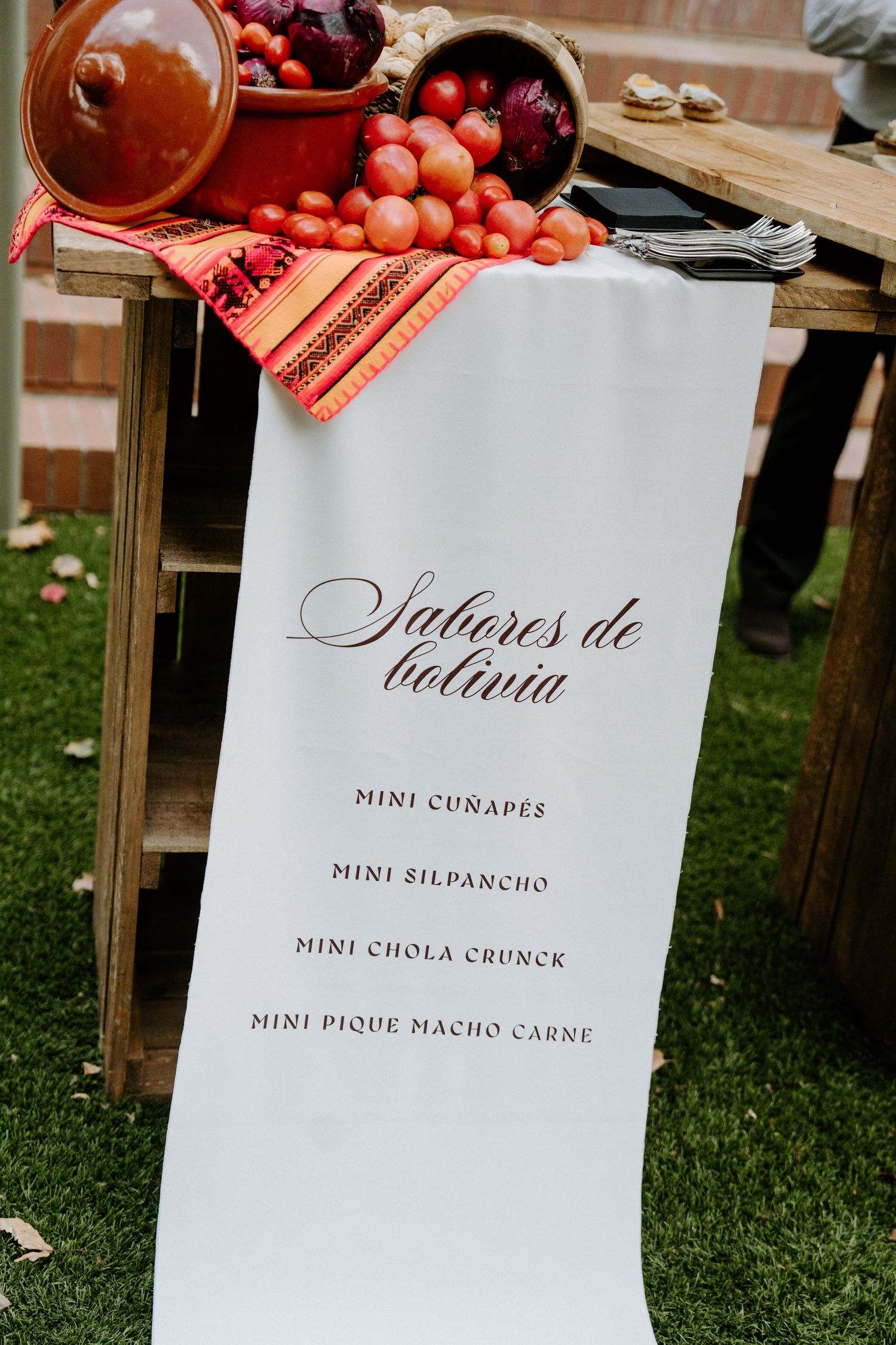 Bolivian wedding menu sign reading Sabores de Bolivia with mini cuñapes, silpancho, chola crunck, and pique macho carne.