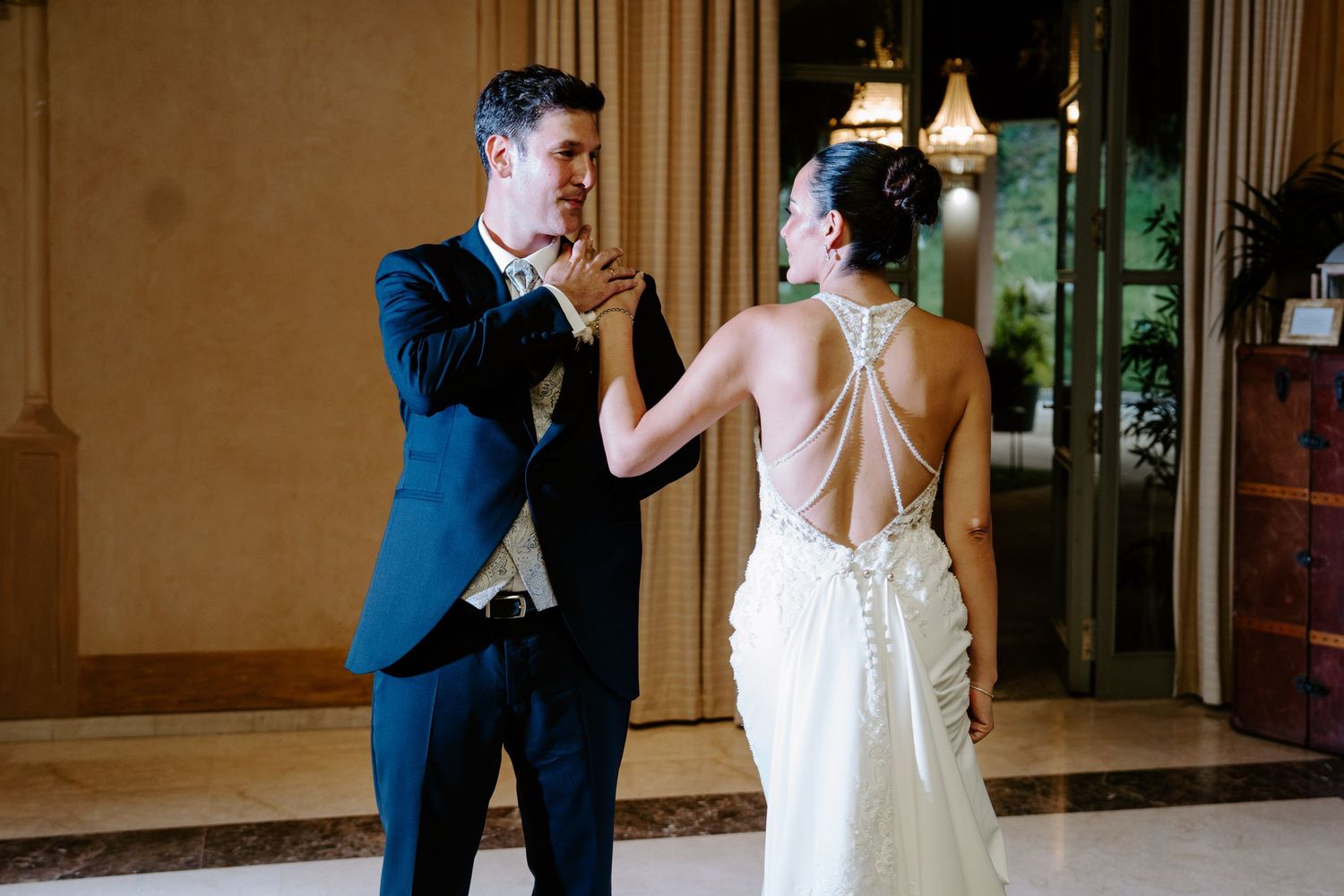 Bride and groom sharing a tender first dance moment in a warmly lit venue.