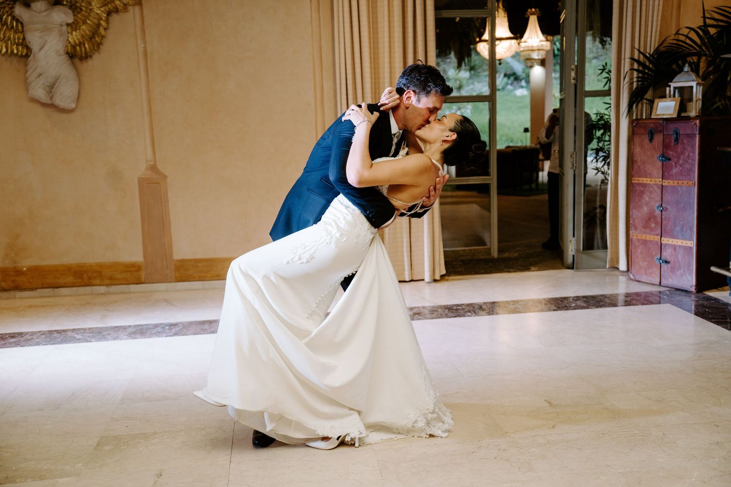 Groom dips bride gracefully on the dance floor during their elegant wedding first dance.