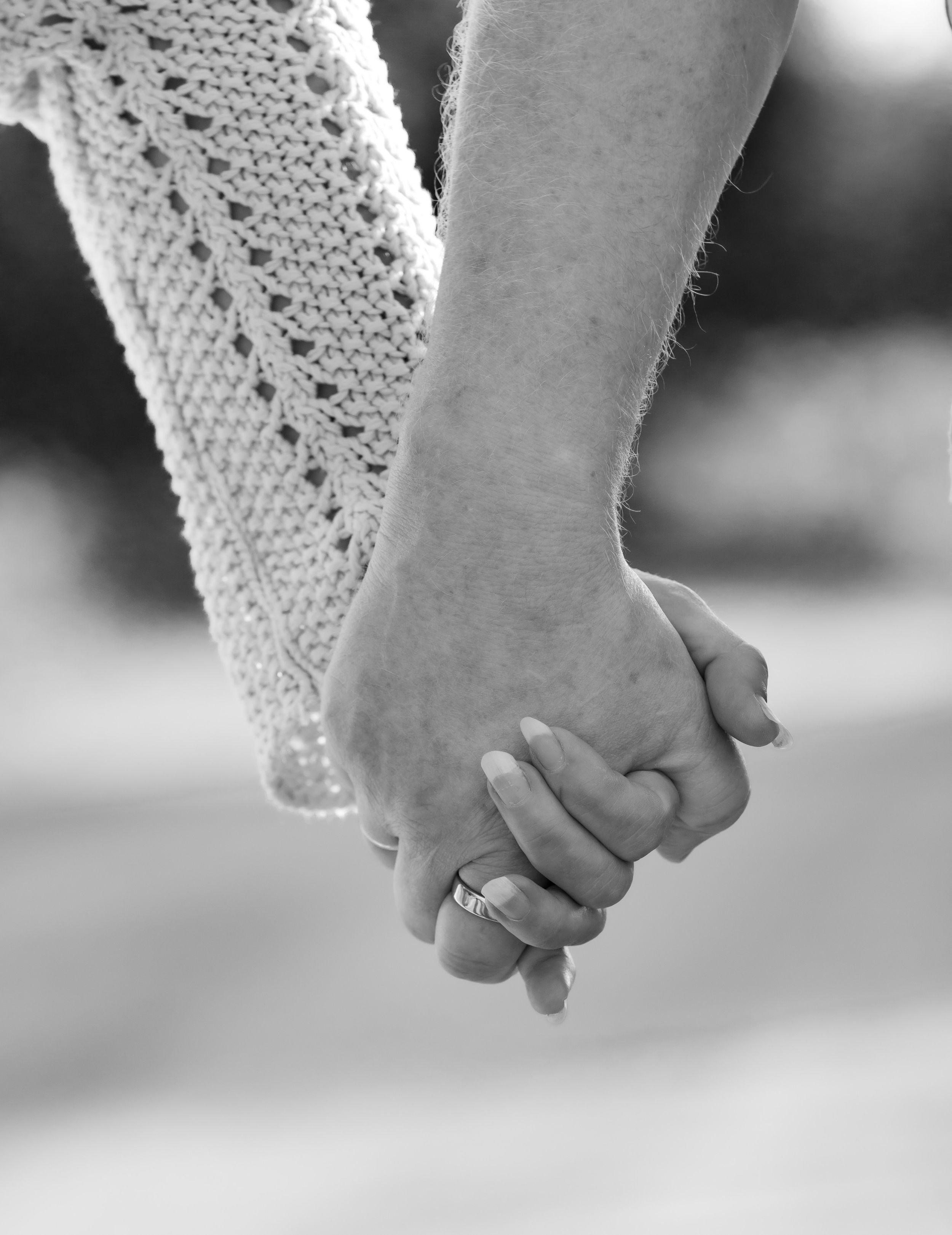 Sort hvitt detaljbilde av par som holder hender. Parfotografering. Bryllup. Forlovelse.