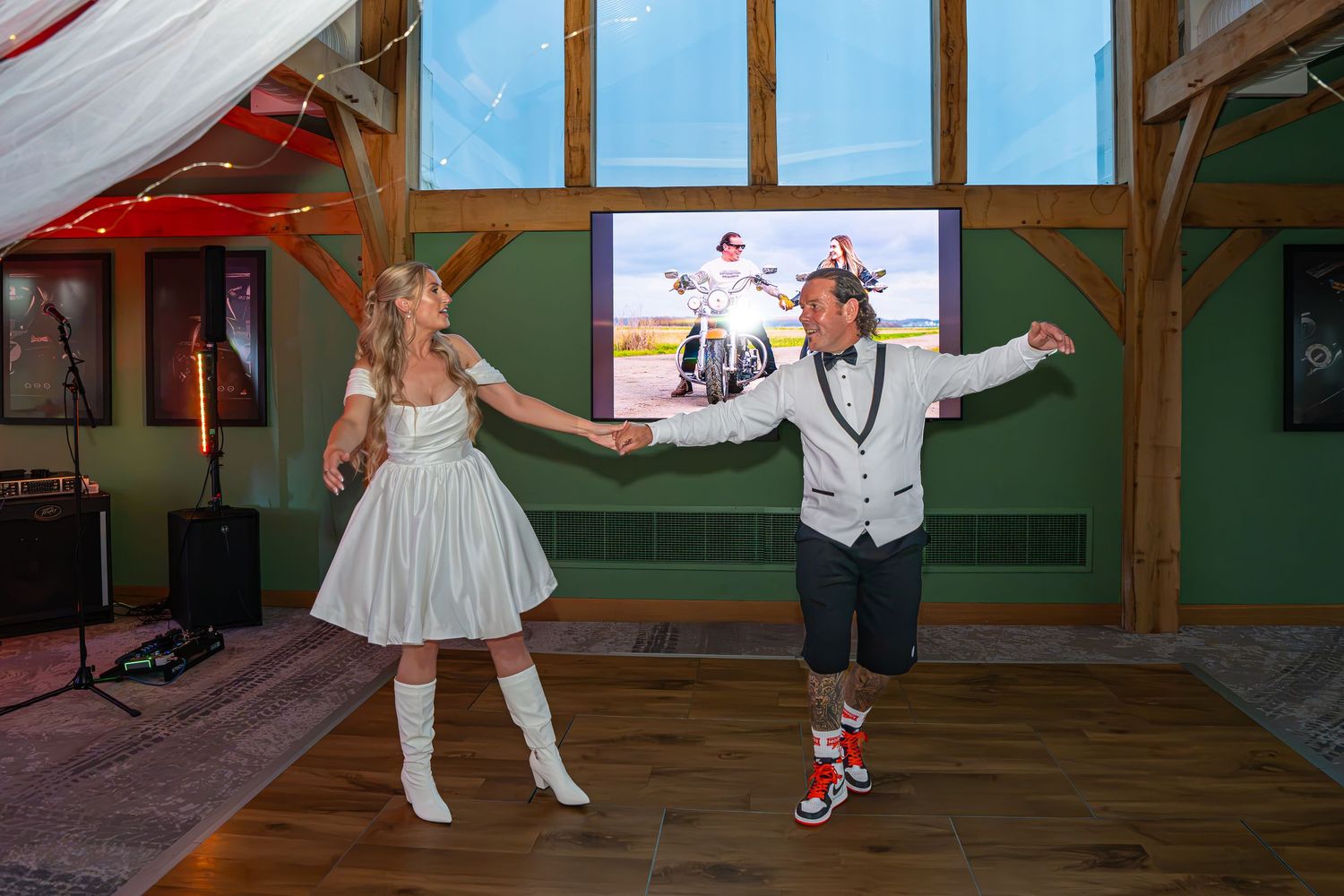 Couple in retro costumes dancing in a barn venue with a motorcycle image on screen behind them. First dance.Yorkshire, Sheffield, Leeds