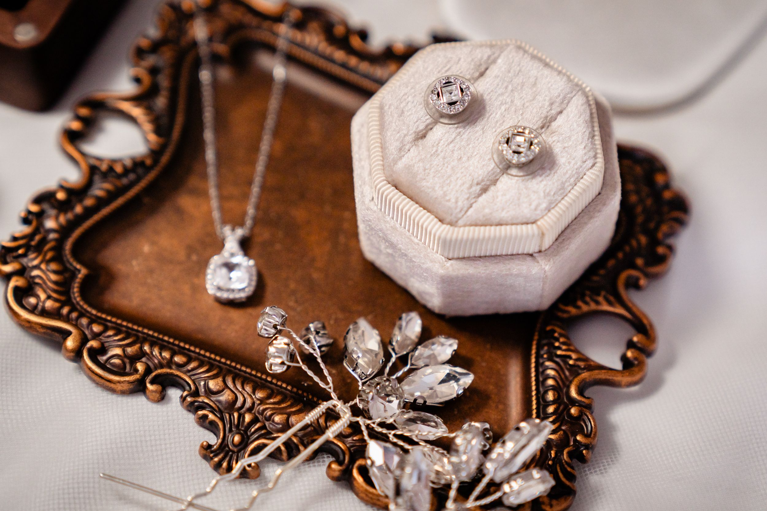 Elegant diamond engagement ring and necklace set displayed in a white velvet jewelry box.