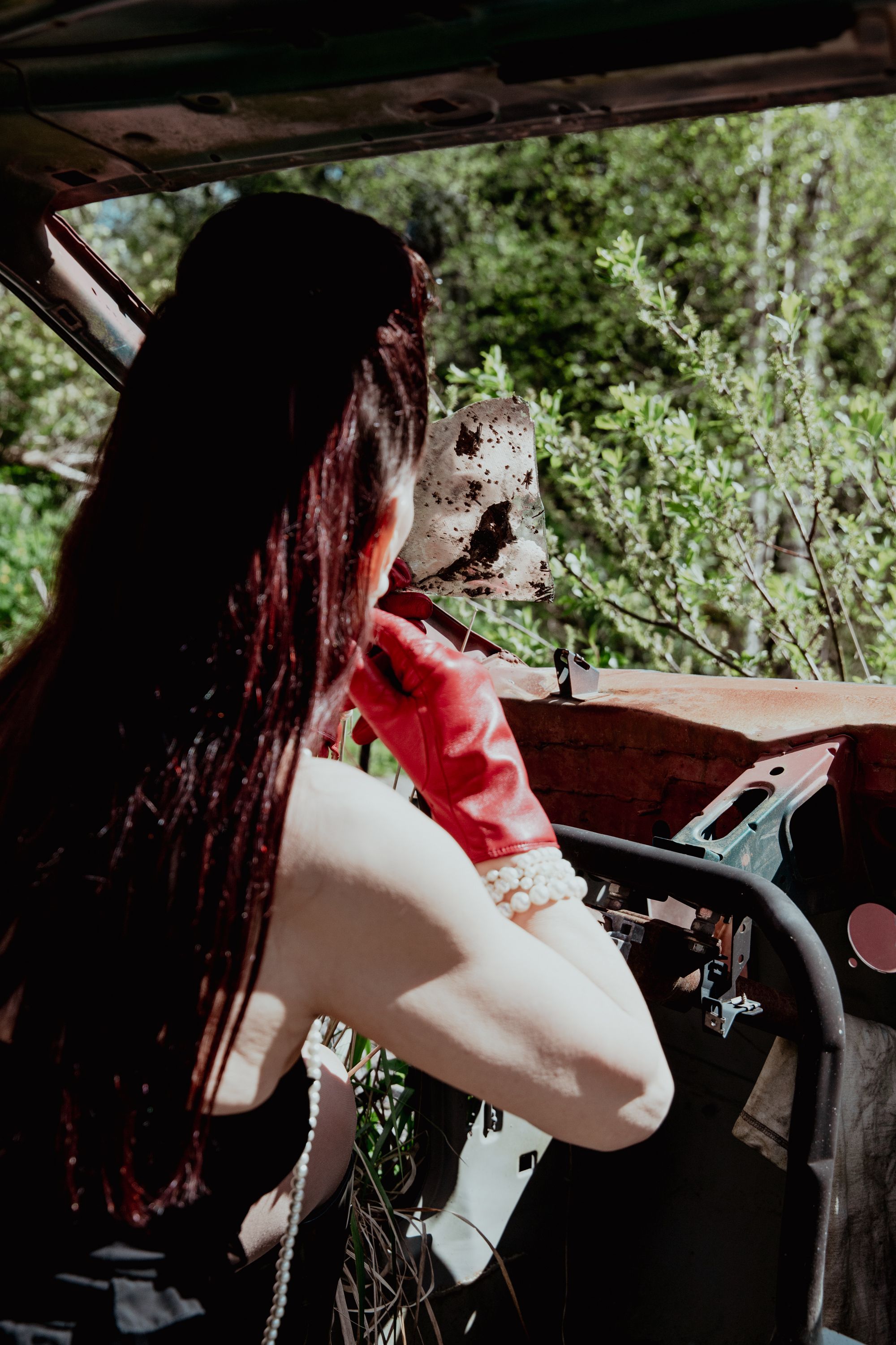 A Woman in a broken car adding lipstick