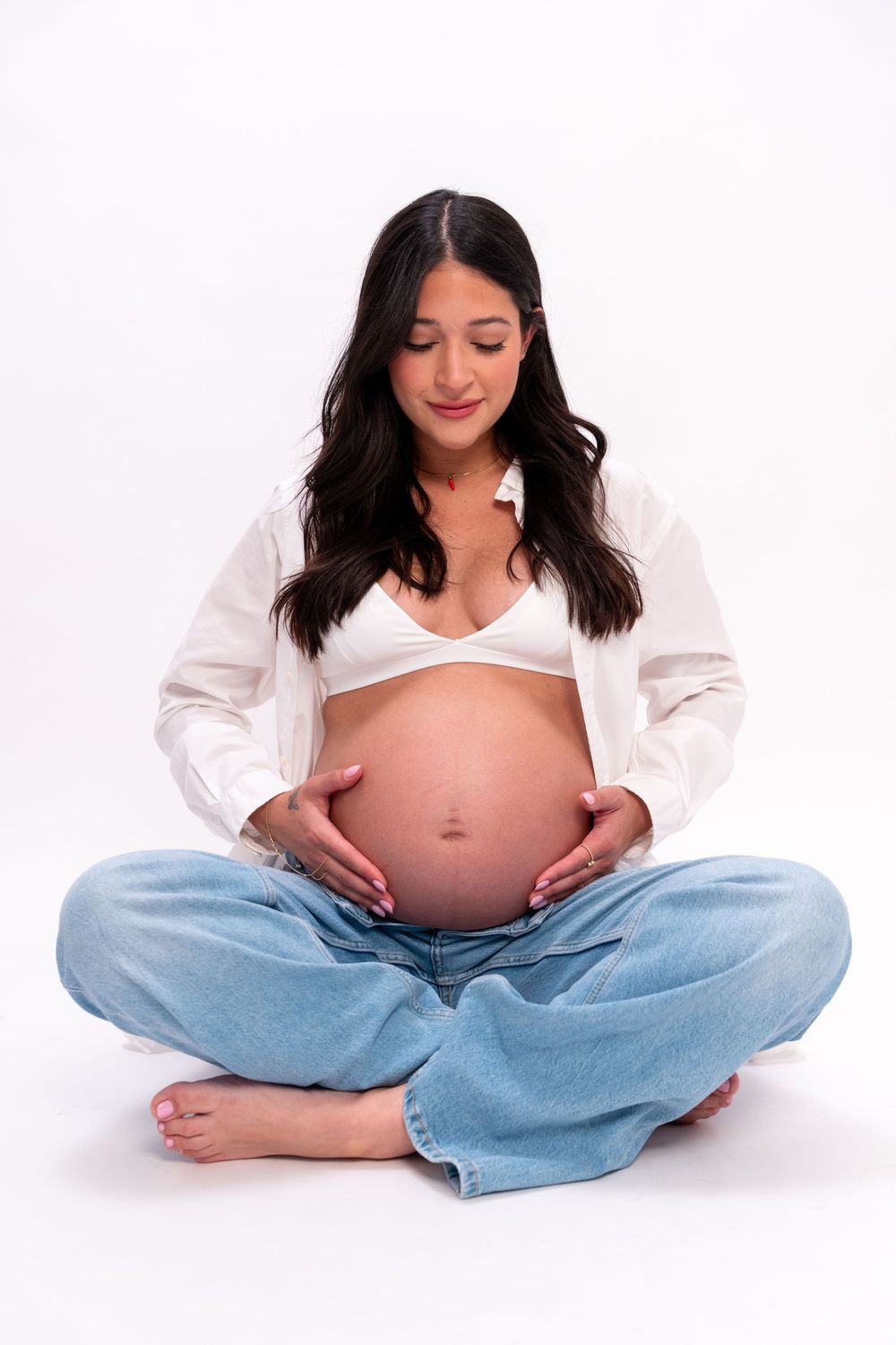 Minimalist studio maternity portraits celebrating pregnancy with soft light, timeless styling, and elegant natural poses.