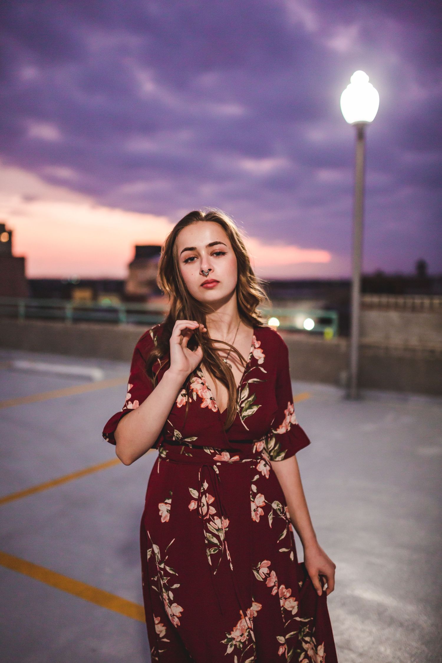 Dramatic dusk portrait with street lamp and flowing burgundy dress.