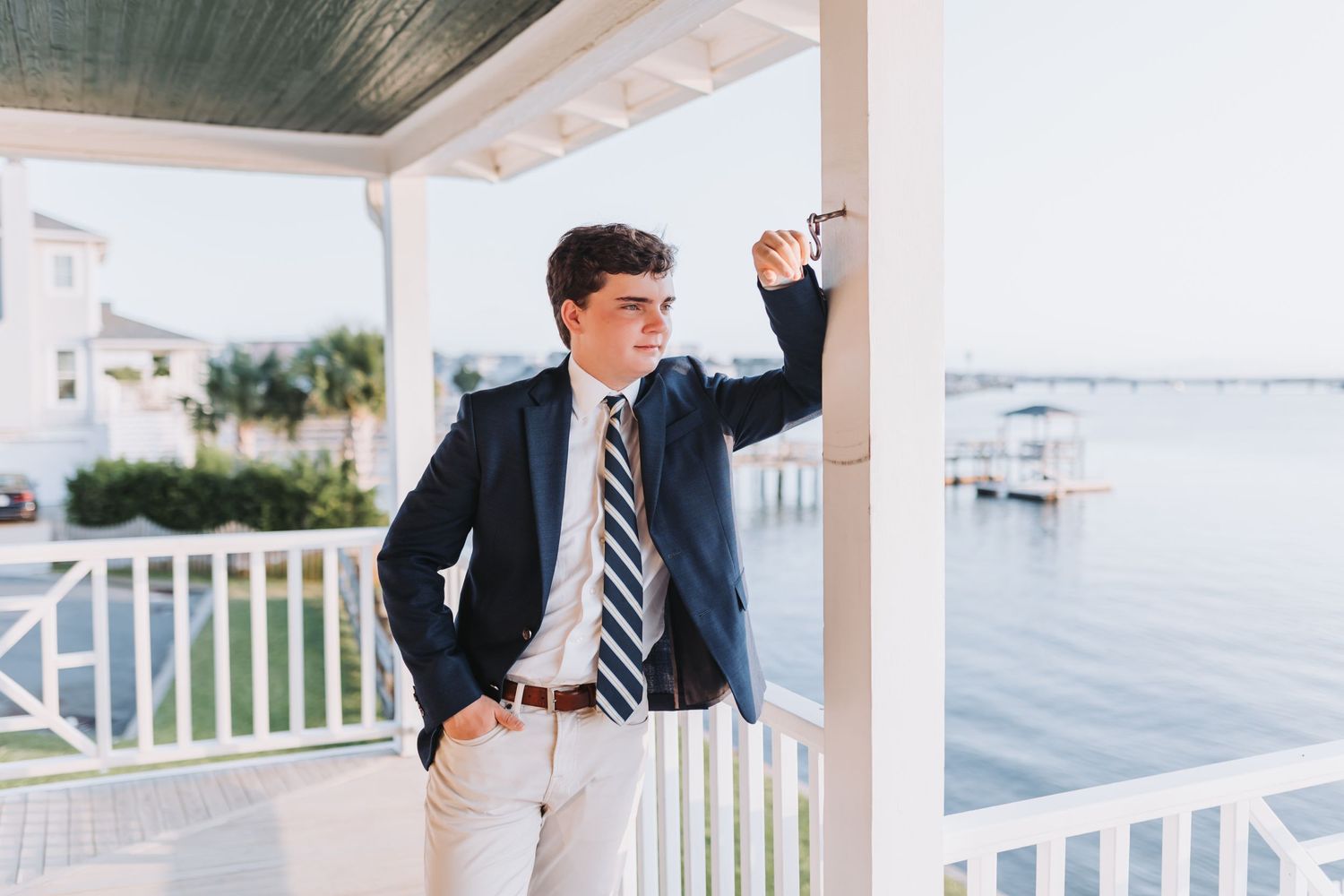 Professional outfit with navy blazer against nautical backdrop on white porch.