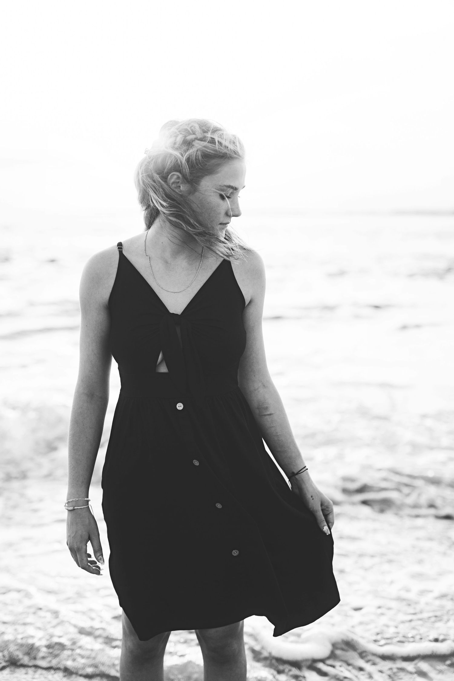 Black and white beachside portrait featuring black button-down sundress.