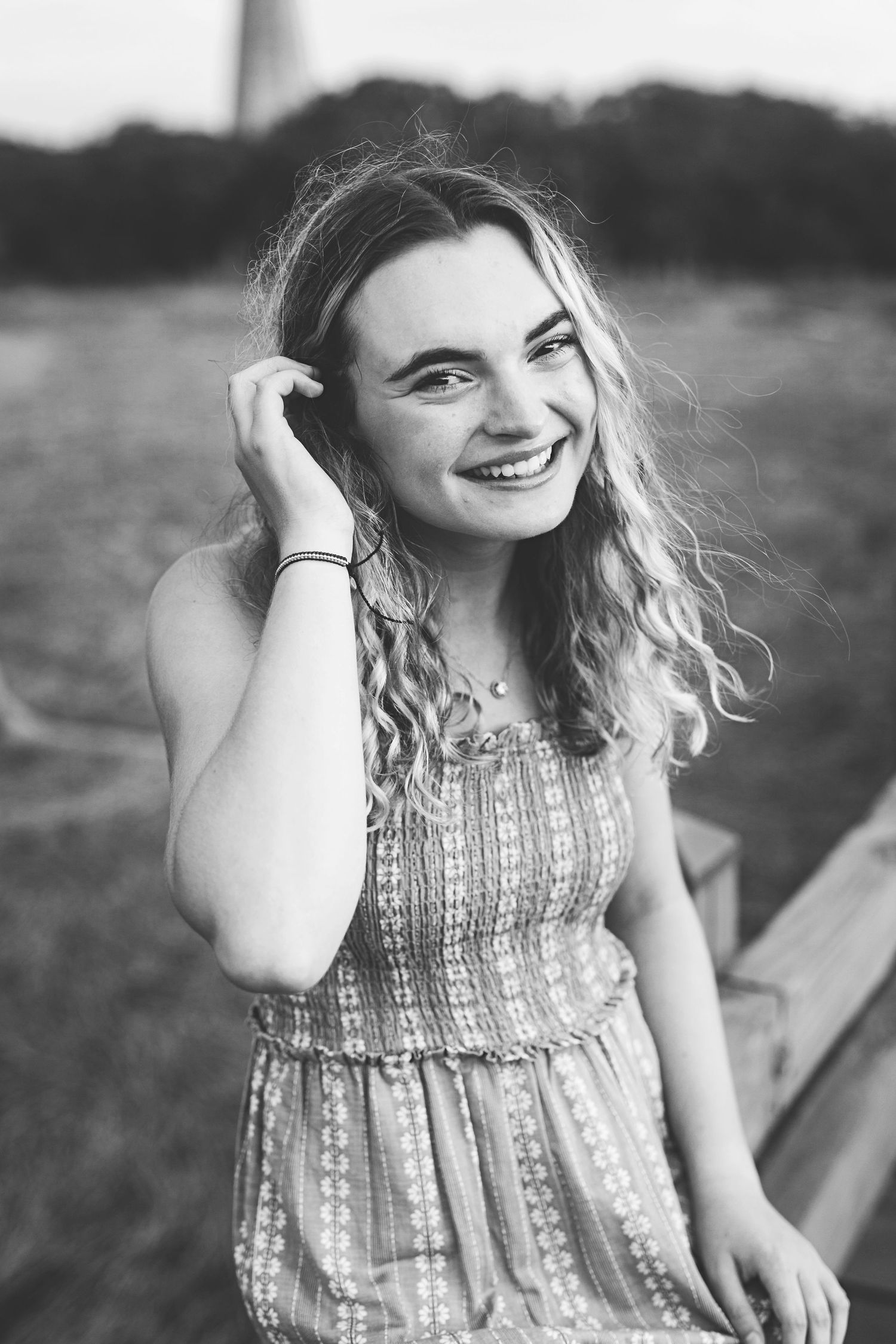 Natural black and white portrait with joyful expression and wavy hair.