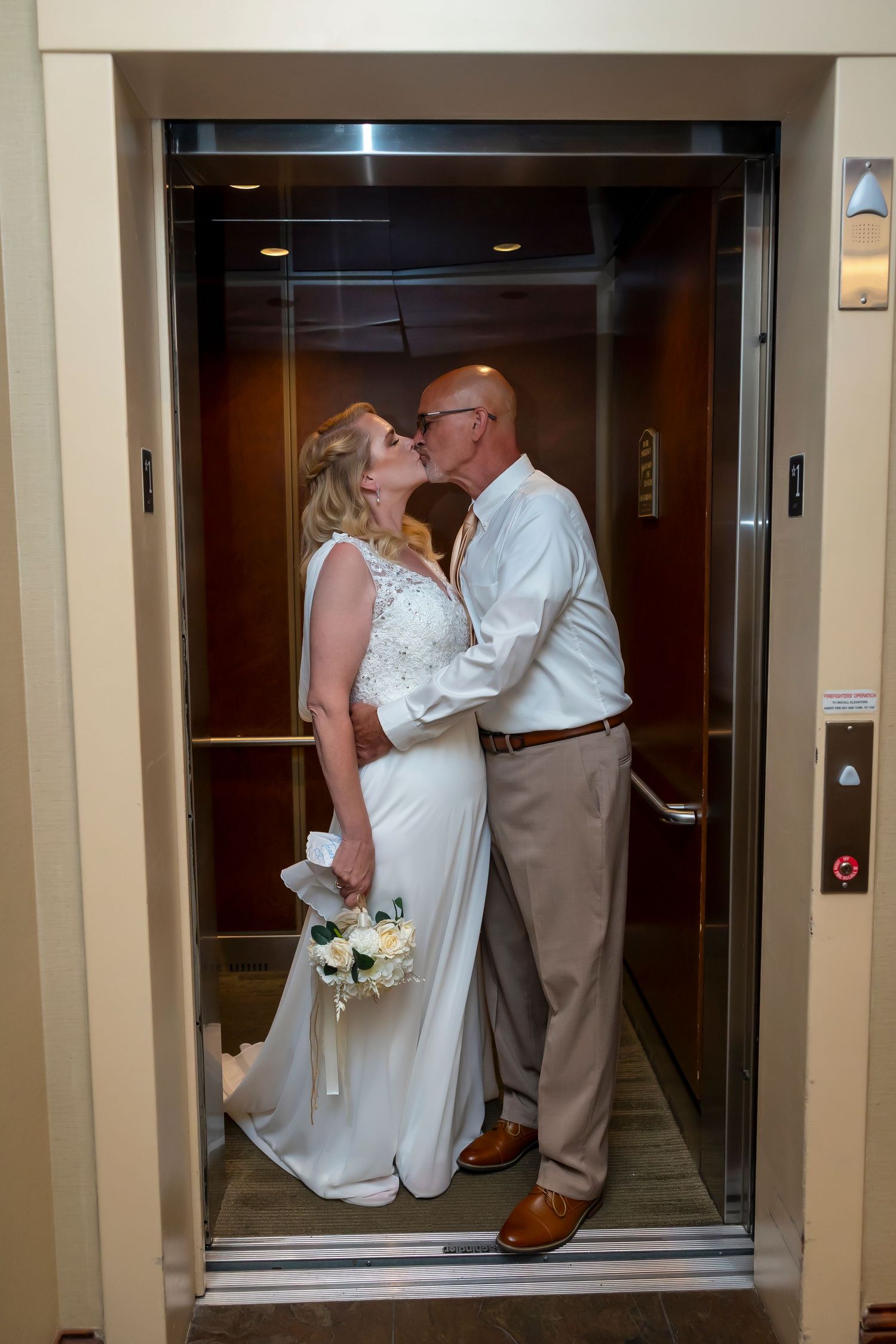 Bride and groom engaged in kiss in elevator Boise Elopement ©Milestones Studios LLC