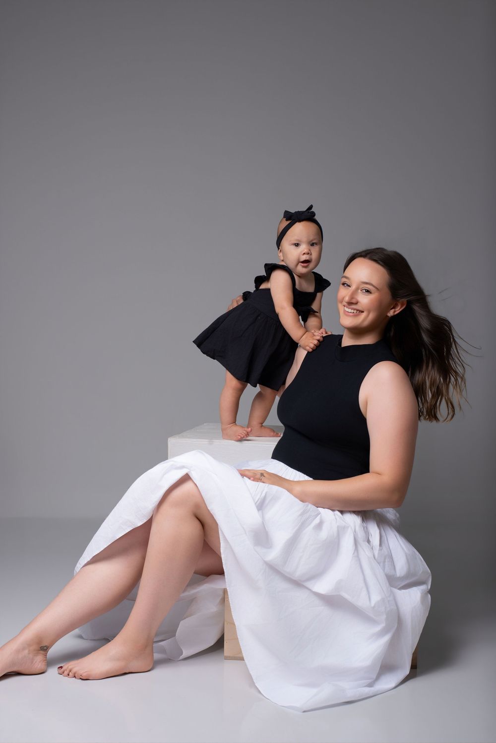 Mother holding twin babies during milestone photography session in Nashville
