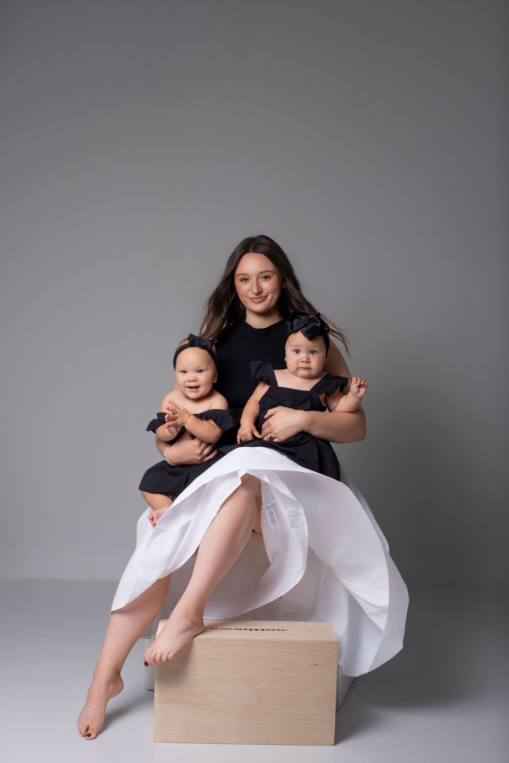 Mother holding twin babies in elegant Nashville photography studio