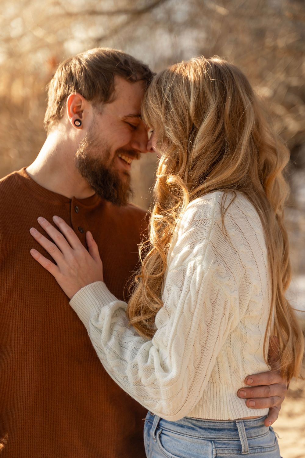 Couple's photo in the winter, white sweaters and jeans at golden hour