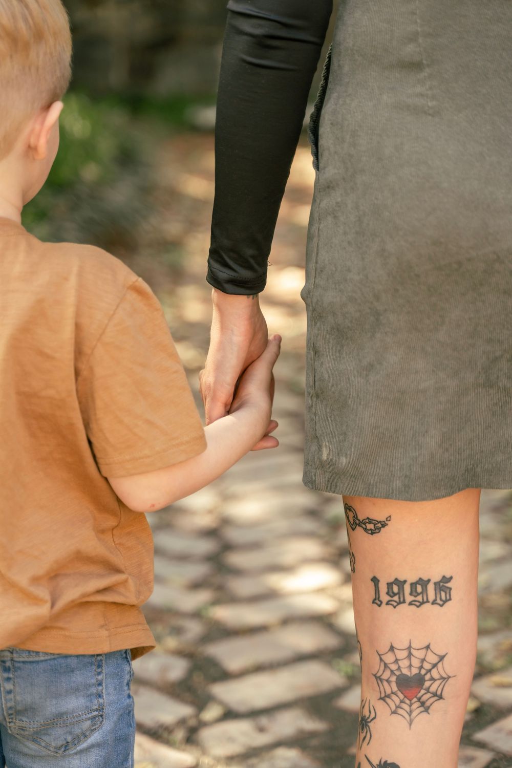Mother and son photo session, holding hands on a brick path