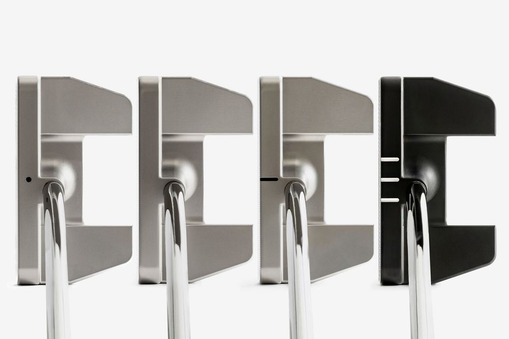 Four golf putters displayed side by side, ranging from silver to black finishes, showcasing modern mallet-style designs.