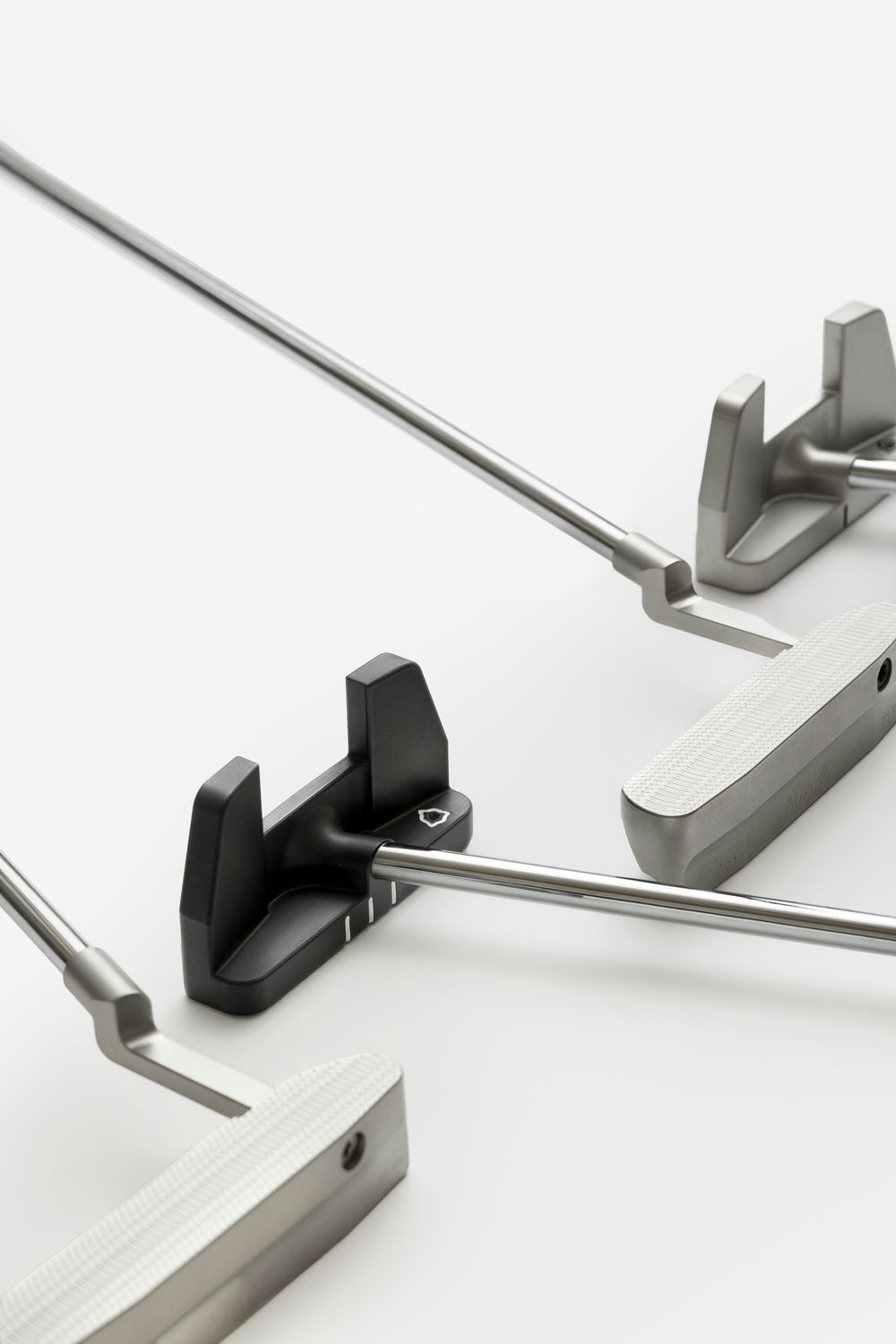 Stainless steel surgical retractors with black handle clamp on white background.
